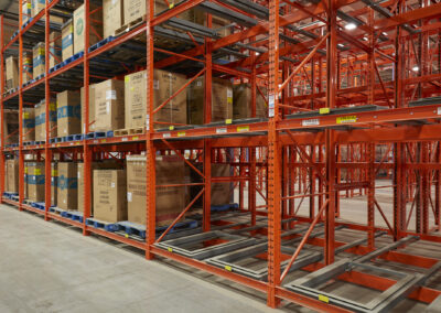 Three-deep roll-formed pushback racking at Home Hardware, four levels high, used for storing appliances like stoves and dishwashers.