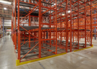 Three-deep back-to-back pushback racking at Home Hardware, featuring roll-formed construction and yellow end-of-row protection to prevent rack damage.