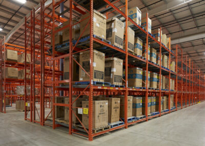 Three-deep back-to-back pushback racking with adjacent double deep rack at Home Hardware, roll-formed and four levels high, used for appliance storage with reinforced front frames.