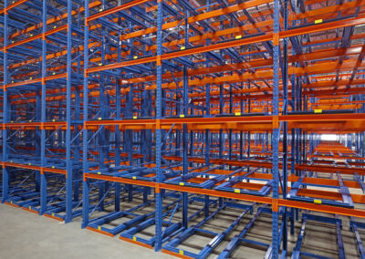 Three-deep back-to-back pushback racking at Mevotech, floor-mounted first level and six levels high, designed for auto parts storage in custom pushback colours.