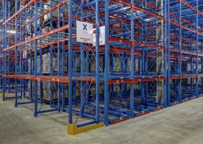 Three-deep back-to-back pushback racking at Mevotech, with selective rack end-capping at the cross aisle, floor-mounted first level, six levels high, for auto parts storage in custom pushback colours.