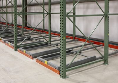 Two-deep floor-mounted pushback racking against a wall at Grand River Enterprises, using teardrop-style support racking for cigarette storage, with front angle beam supplied by 3D Storage.