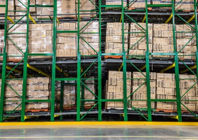 Six-deep back-to-back pushback racking at Dollarama in Laval, Quebec, five levels high, in green and yellow Dollarama colours for high-density storage.